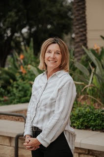 Woman in front of bookshelf smiling