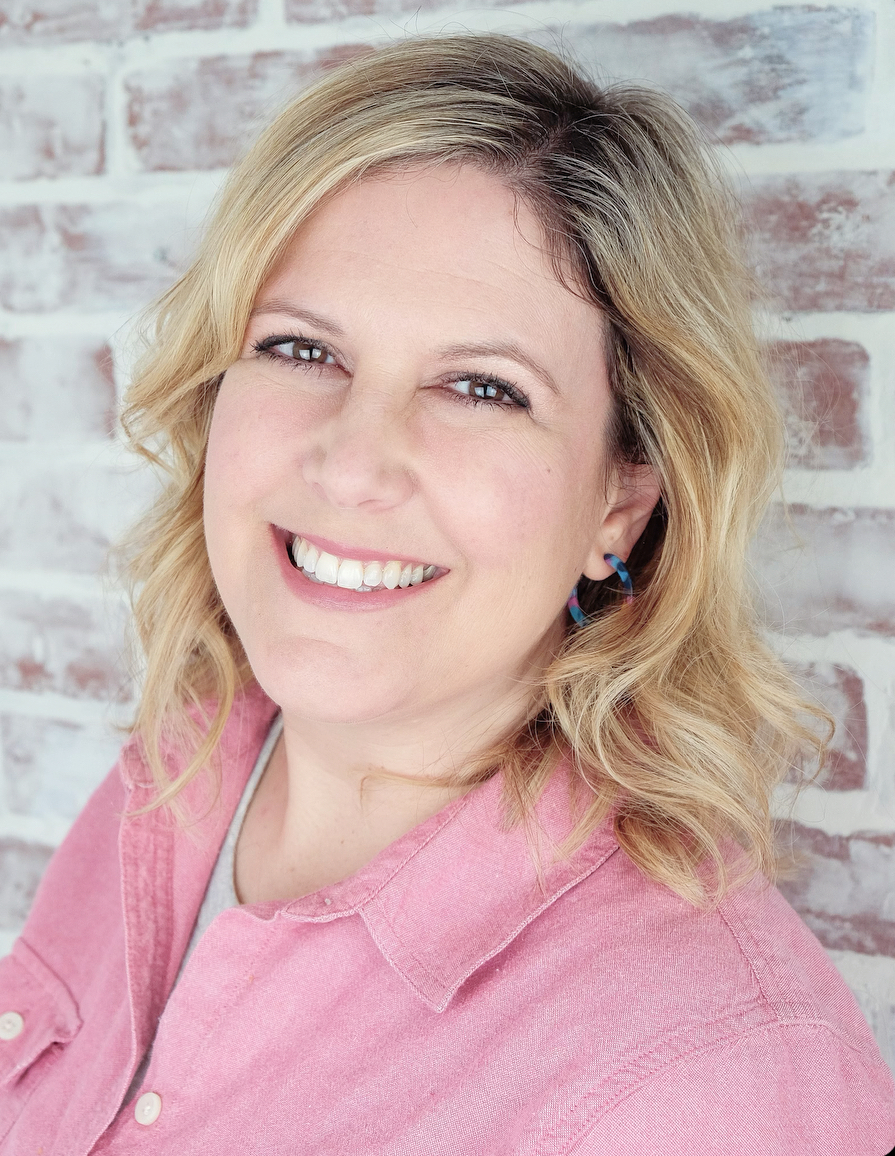 Woman in front of brick wall smiling